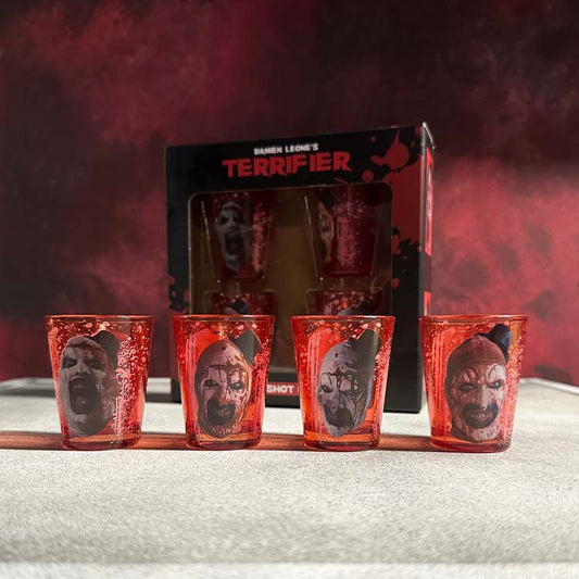 Set of red shot glasses with horror-themed designs in front of a 'Terrifier' branded box.